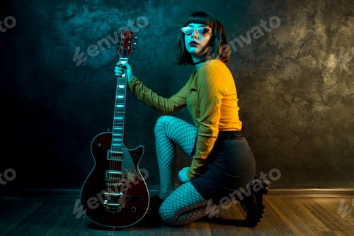 Preview: Stylish Woman with Guitar Posing in Studio