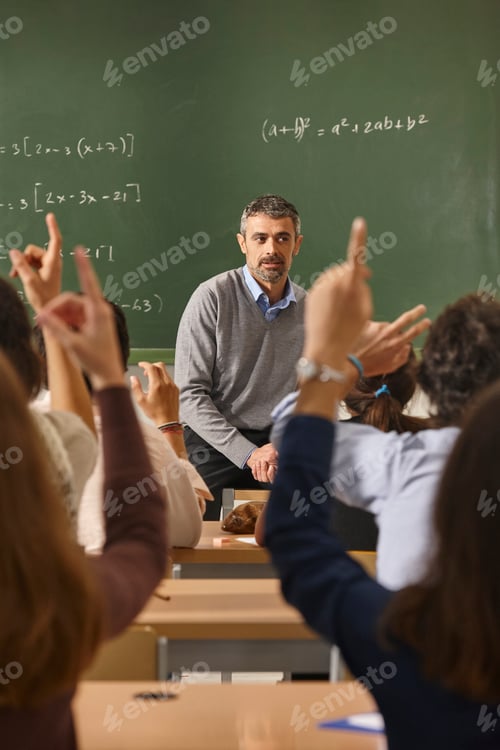Preview: Teacher in Classroom with Students Raising Hands