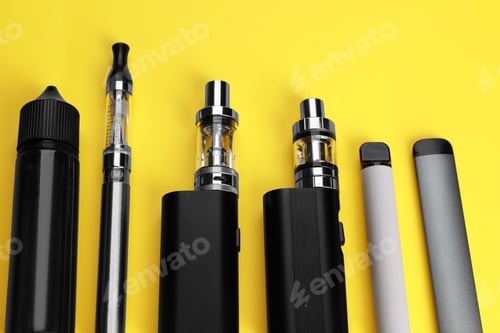 Preview: Different electronic cigarettes on yellow background, above view