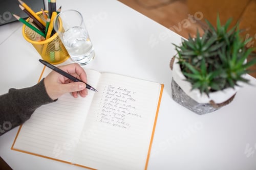 Preview: Woman writing down list of rules for mental health to reduce stress from distant job during lockdown