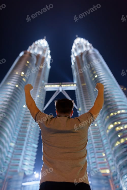 Preview: Young handsome man against view of the Petronas Twin Towers at n