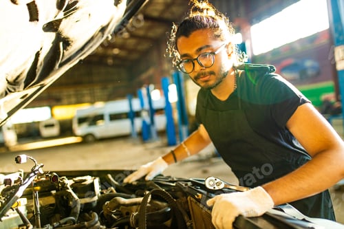 Preview: indian man auto mechanic working indoors in car shop