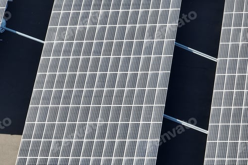 Preview: Aerial view of blue photovoltaic solar panels mounted on industrial building roof