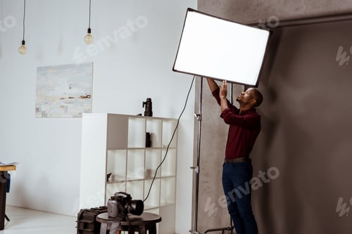 Preview: african american photographer getting ready for photoshoot in studio