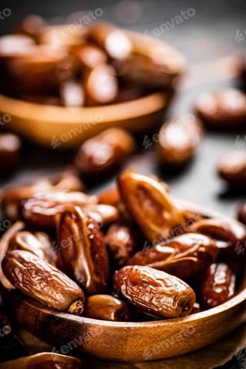 Preview: Delicious dates on a wooden plate.