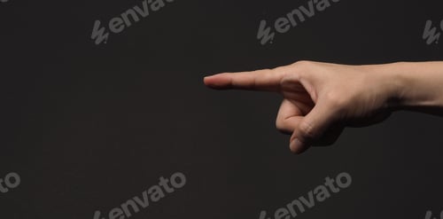 Preview: Index finger pointing to something, isolated on black background.