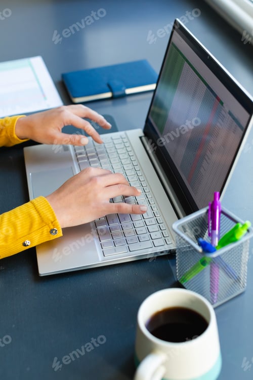 Preview: Hands of caucasian woman working from home and using laptop
