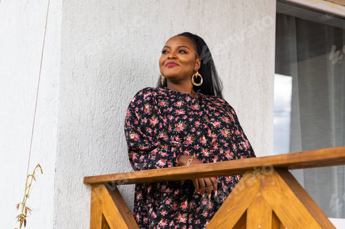 Preview: African american woman relaxing and enjoying sun while standing at terrace or balcony at sunlight at