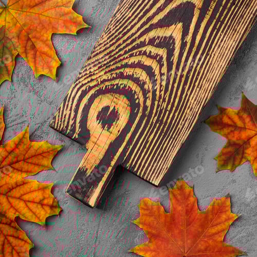 Preview: Handcrafted old wooden cutting board with autumn leaves on concrete background