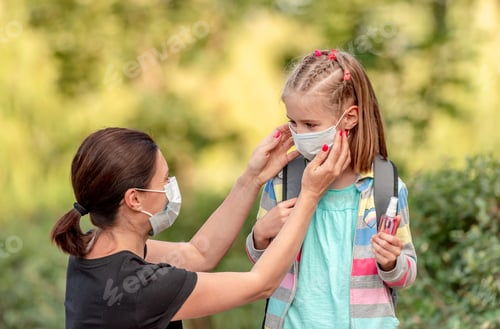 Preview: Mother putting mask on daughter before school