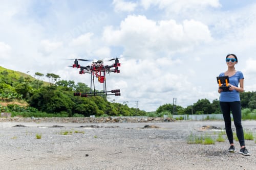 Preview: Young woman control Drone flying at outdoor