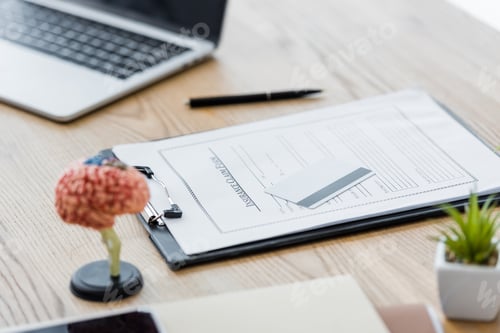 Preview: laptop, insurance claim form and credit card on wooden table