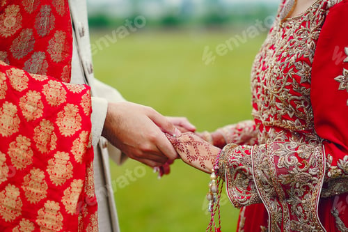 Preview: hindu bride walks behind husband holding garb