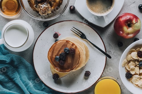 Preview: top view of tasty healthy breakfast with pancakes, fruits and granola on grey