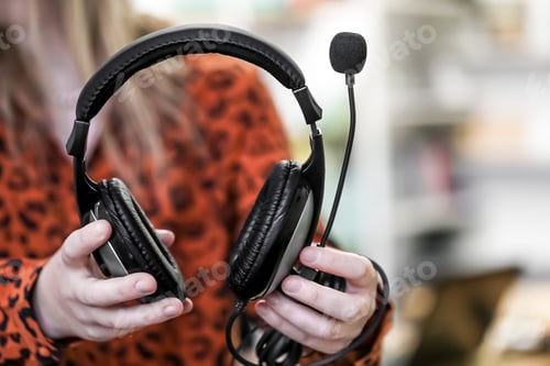 Preview: Headphones in female hands, close-up, blurred background.