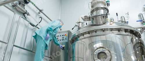 Preview: Pharmaceutical factory woman worker in protective clothing operating production line in sterile