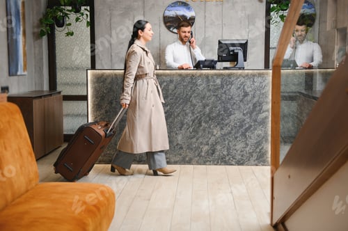 Preview: Female guests come with bags and suitcases to the hotel reception in the lobby