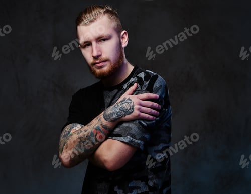 Preview: A man with tattoos on arms.