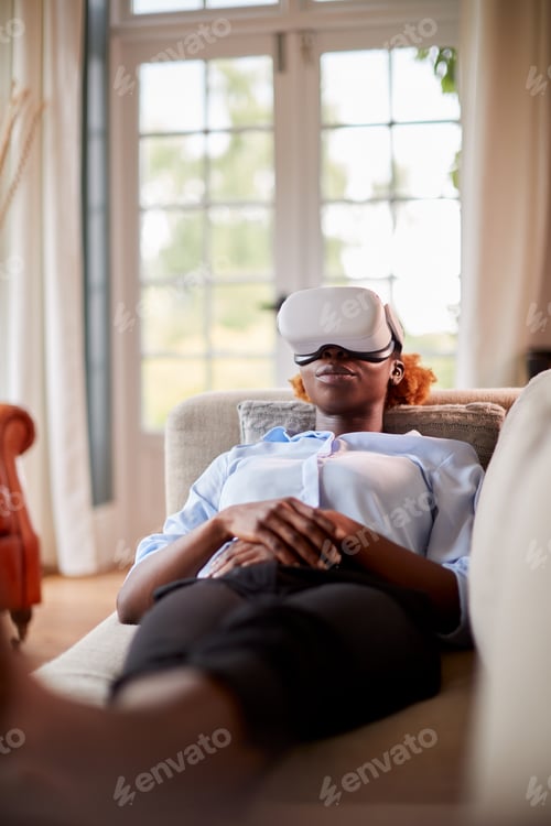 Preview: Woman Relaxing Lying On Sofa At Home Wearing VR Headset And Interacting With AR Technology