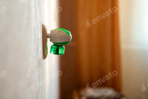 Preview: Mosquito repellent with plug into the socket at home closeup. Insect repellent diffuser.