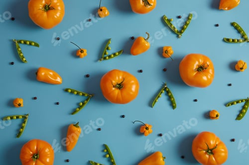 Preview: Freshly harvested yellow heirloom tomatoes, peas and habanero pepper on blue background. Juicy ripe