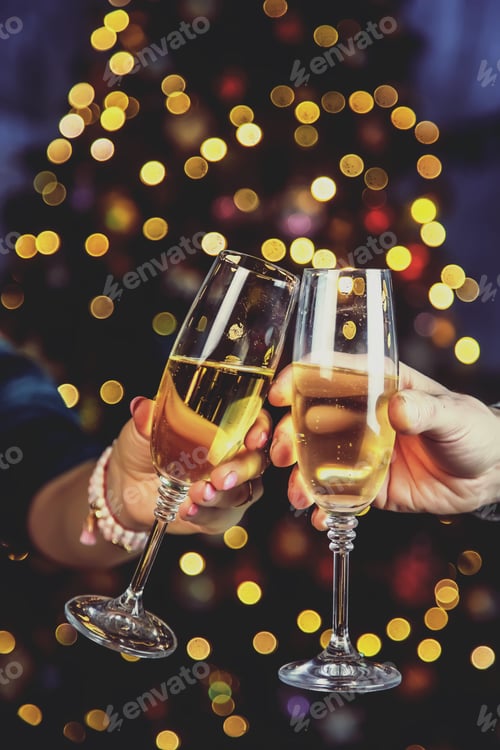 Preview: Champagne in hand against the background of the Christmas tree. People. Selective focus.