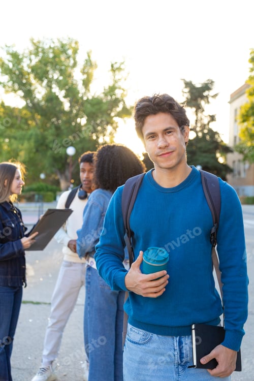 Preview: Young student holding coffee cup and notebook on campus