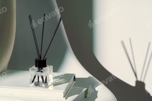 Preview: Liquid home perfume in glass diffuser with sticks on chair