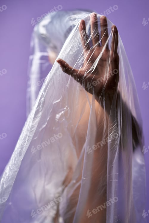 Preview: Portrait of young transgender with transparent plastic bag on body close up. Stop hand symbol