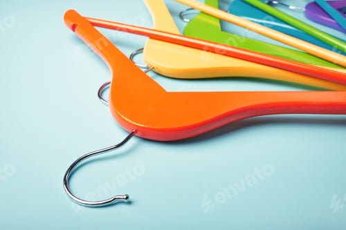 Preview: Multi-colored clothes hangers on a blue background. Concept of shopping and sale.