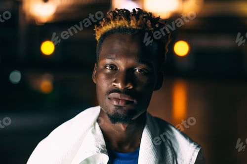 Preview: Portrait of young black man with colored orange fire hair at night