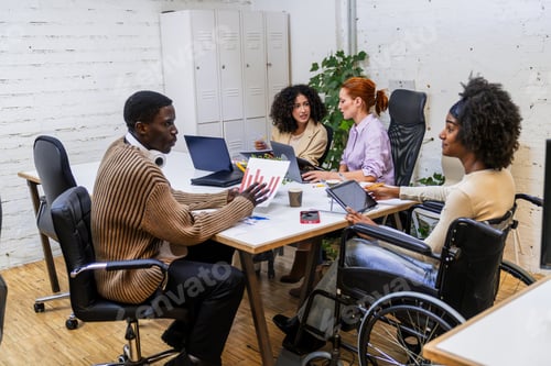 Preview: Diverse business team discussing charts and data in coworking space