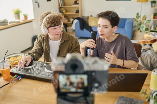Preview: Cute brunette girl singing or speaking in microphone in front of laptop