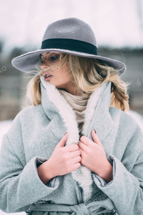 Preview: Beautiful winter portrait of young woman in the winter snowy scenery.