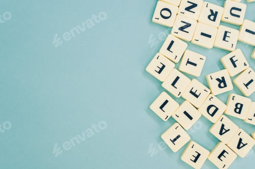 Preview: Top view of the alphabet letters on the wooden pieces on the blue surface - space for text