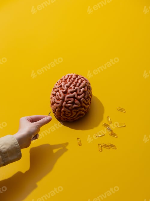 Preview: Female holds pills near brain on yellow background