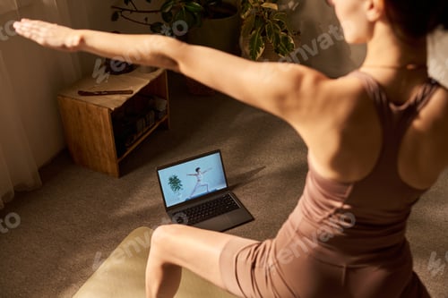 Preview: Young Adult Caucasian Woman Practicing Yoga Following Online Video Instruction