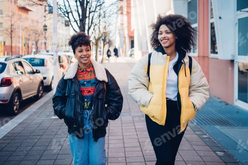 Preview: Two cool young women strolling on urban sidewalk