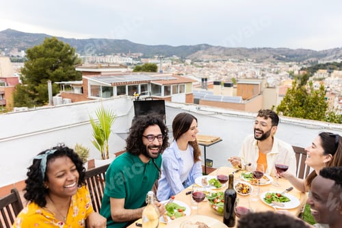 Preview: Young group of people enjoying dinner reunion at rooftop home.