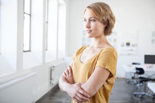 Preview: Portrait of young woman with crossed arms in a creative office
