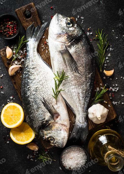 Preview: Fresh fish dorado on black stone table.