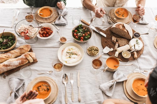 Preview: Close up fresh bread with cheese and bowls with pumpkin soups on lunch in cozy cafe