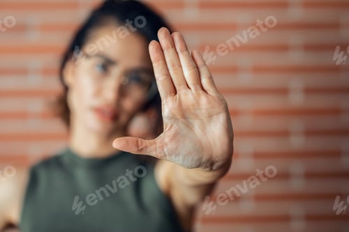 Preview: Fighter woman making stop sign with hands while saying no looking at camera.