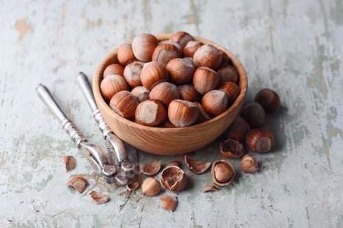 Preview: Wooden plate full of hazelnuts with silver nutcracker