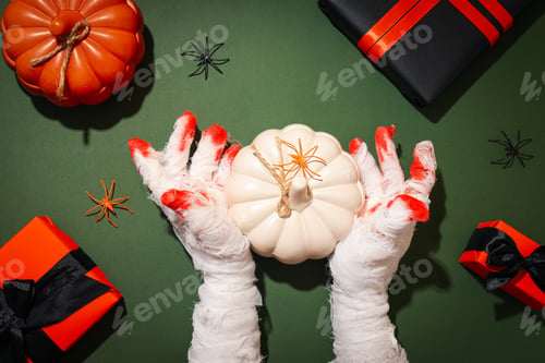 Preview: Hands wrapped in a bandage with a pumpkin and gifts