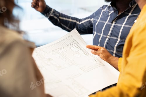 Preview: Business team evaluating architectural blueprints layout for high class space