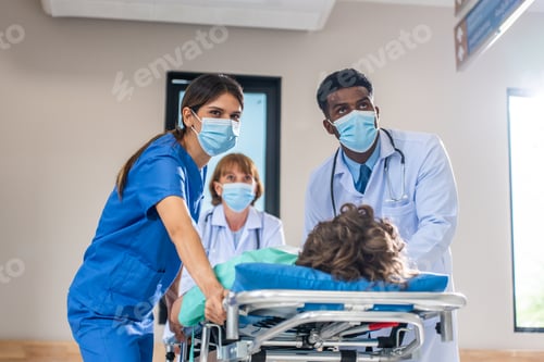 Preview: Group of diverse doctors moving seriously injured patient in hospital.