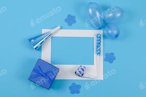 Preview: Empty paper frame, balls, whistle, lollipop candy and gift box on a blue background.
