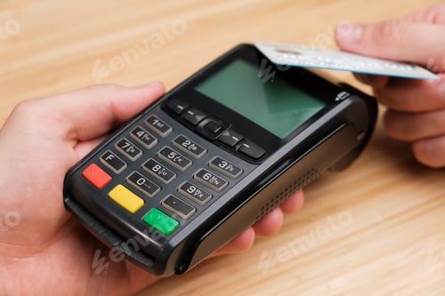 Preview: Close up man hand paying with contactless credit card with NFC technology using wireless payment