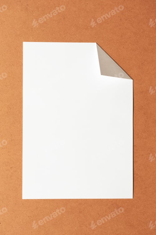 Preview: White empty clean paper sheet with folded corner on cardboard background. Top view, vertical